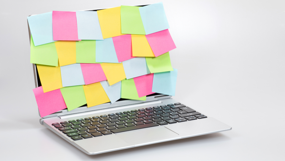 Post-it notes on a laptop screen representing cluttered digital workspace or property law documentation.