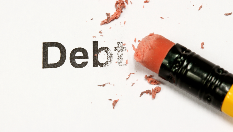 Broken words "Debt" erased with orange crayon, symbolising debt and financial issues.