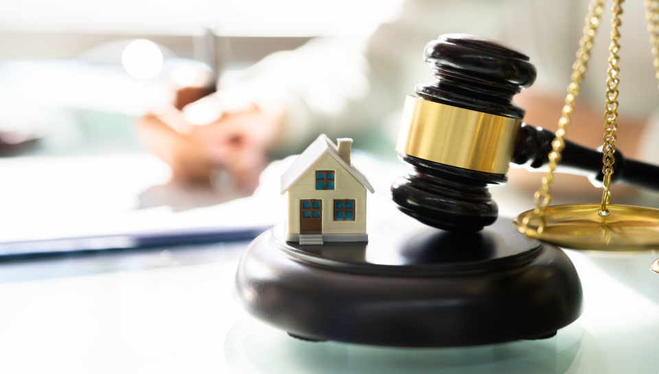 Legal gavel with house and scales of justice for property and civil dispute law in Queensland.