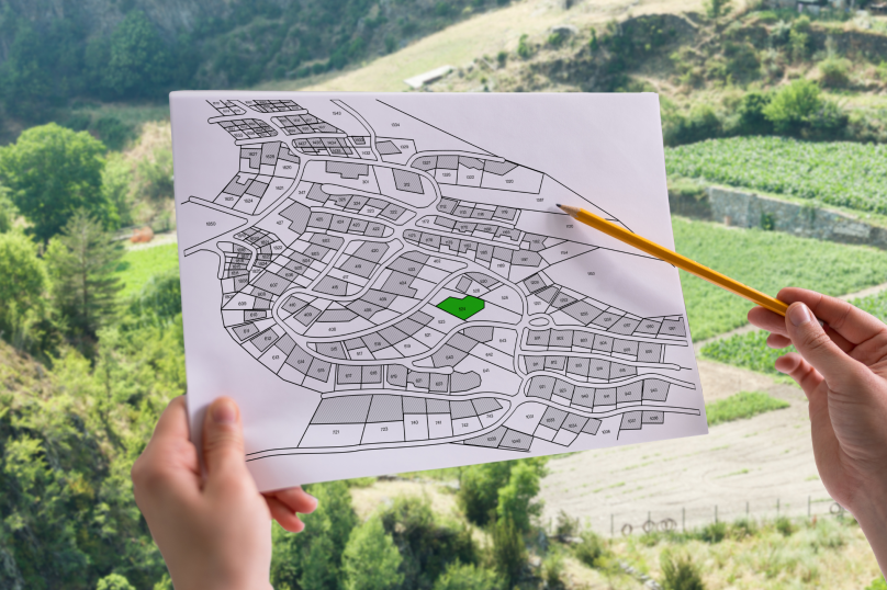 A detailed property subdivision map with highlighted lot in green, outdoor setting in background.