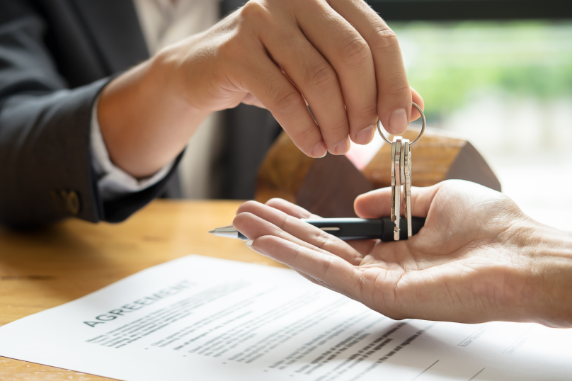 Keys handover for property transaction at Toowoomba law firm in Queensland.