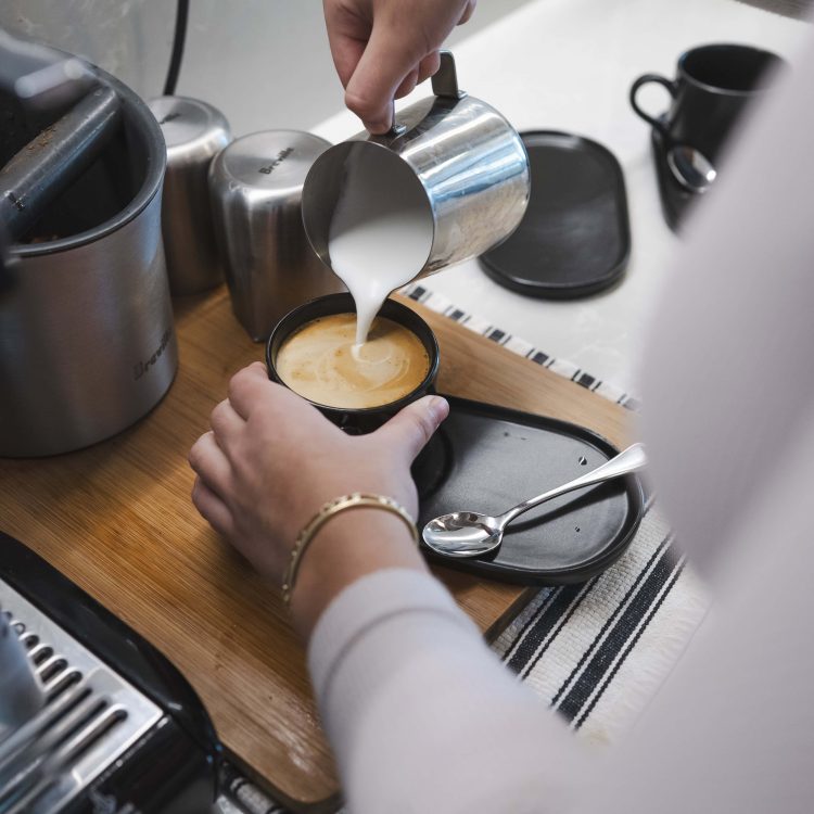 Pour-over coffee being poured into a cup in a cafÃ©.