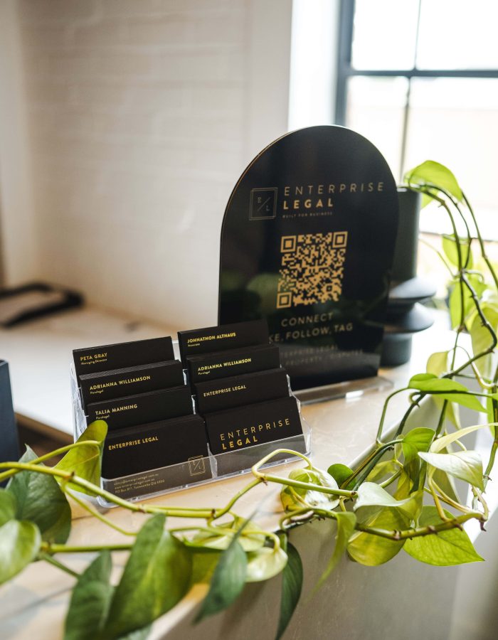 Modern law firm reception desk with business cards and QR code display in Toowoomba, Queensland.
