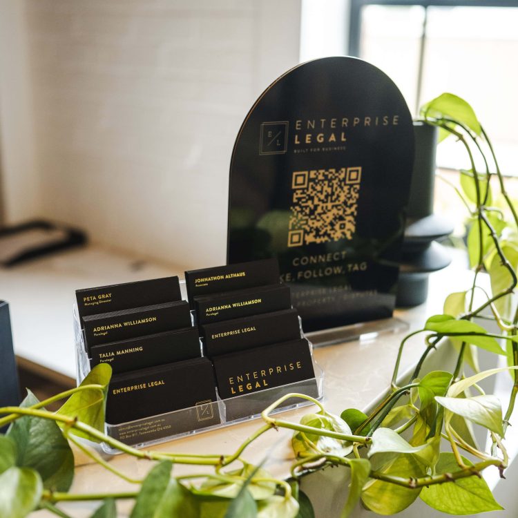Modern law firm reception desk with business cards and QR code display in Toowoomba, Queensland.
