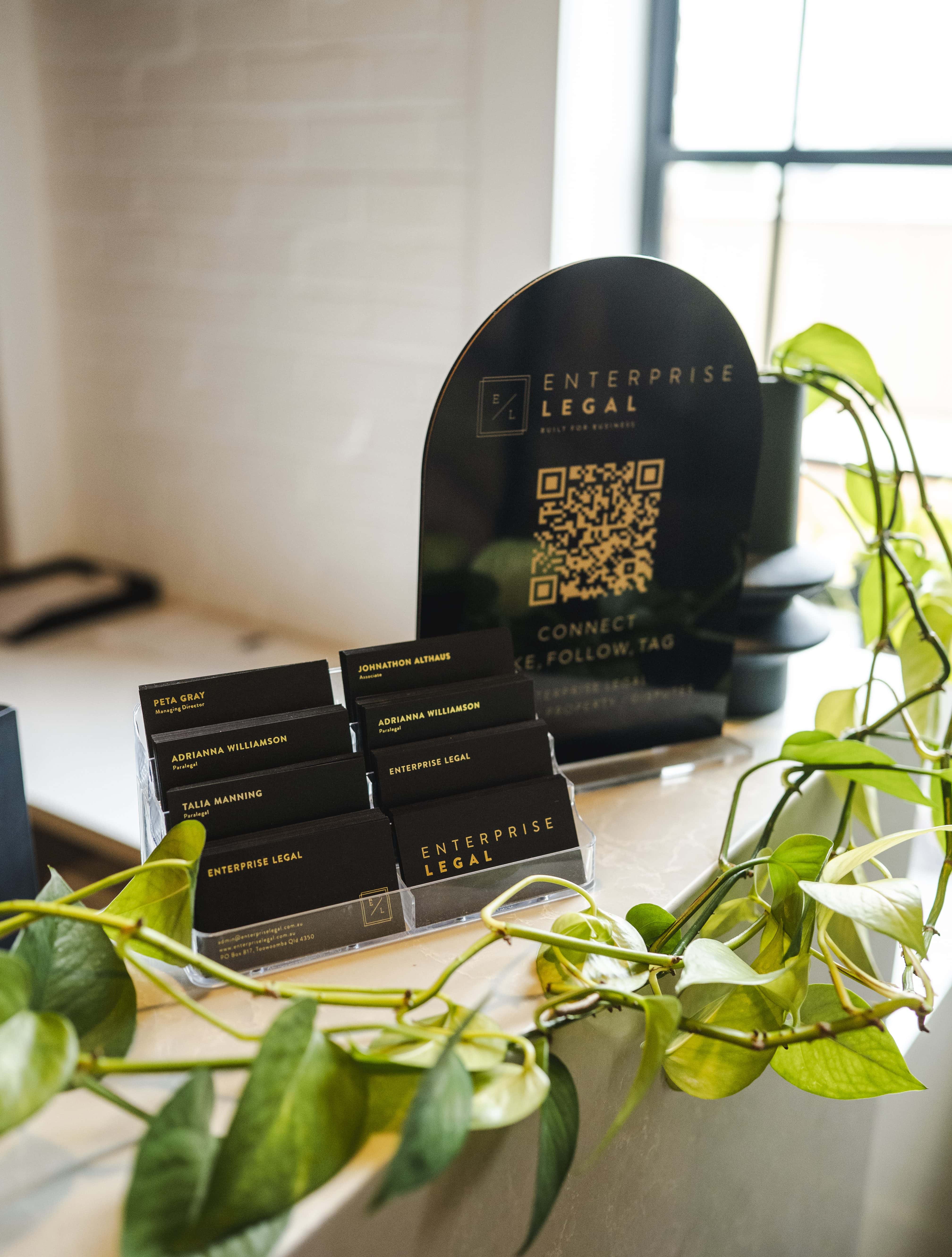 Modern law firm reception desk with business cards and QR code display in Toowoomba, Queensland.