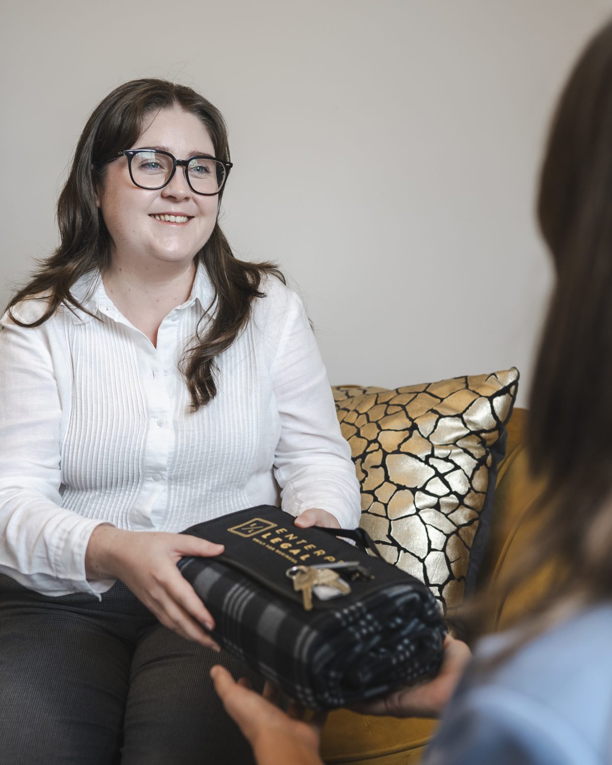 Professional woman handing over legal documents at law firm in Toowoomba, Queensland.