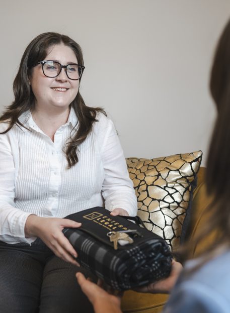 Professional woman handing over legal documents at law firm in Toowoomba, Queensland.