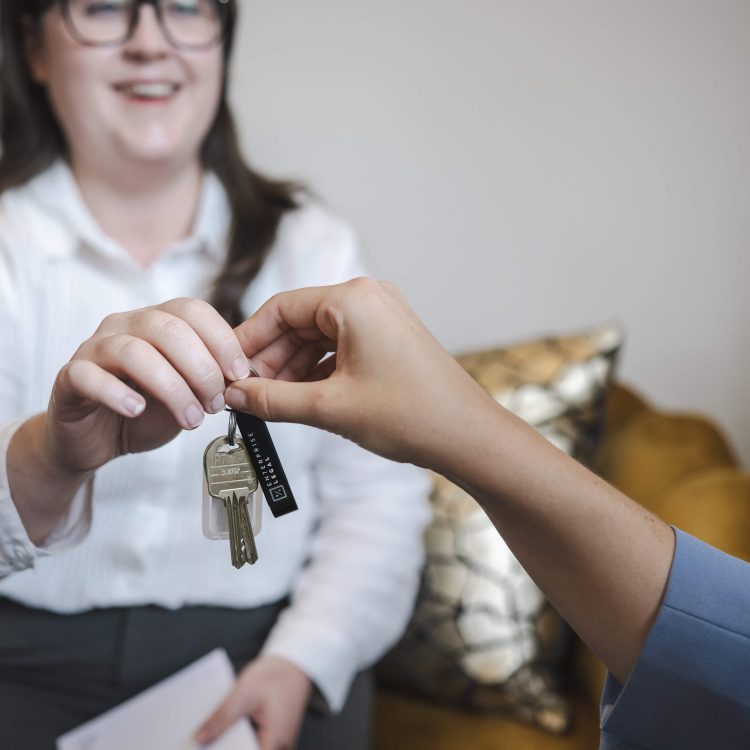 Keys exchanged in property transfer between lawyer and client at Toowoomba law firm.