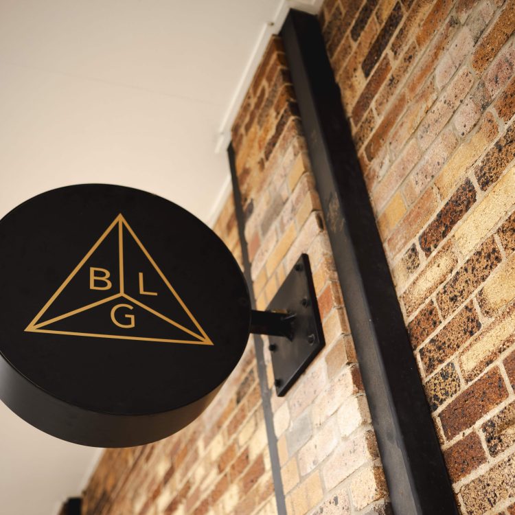 Modern law firm sign with geometric logo on brick wall in Toowoomba, Queensland.