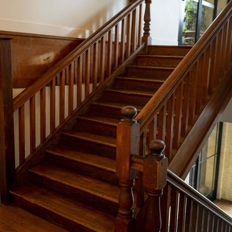 Victorian-style wooden staircase inside a property, real estate and property law concept.