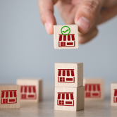 Small wooden blocks with shopfront icons, representing property and business law.