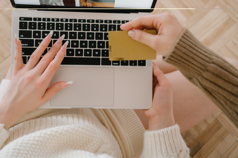 Close-up of a person holding a credit card and using a laptop for online legal services in Toowoomba.