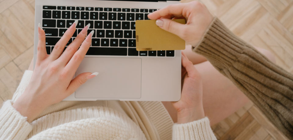 Close-up of a person holding a credit card and using a laptop for online legal services in Toowoomba.
