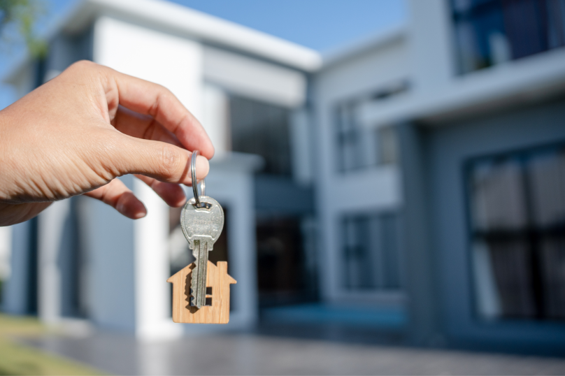 Keys with a house-shaped keychain in front of a modern property in Toowoomba, Queensland.