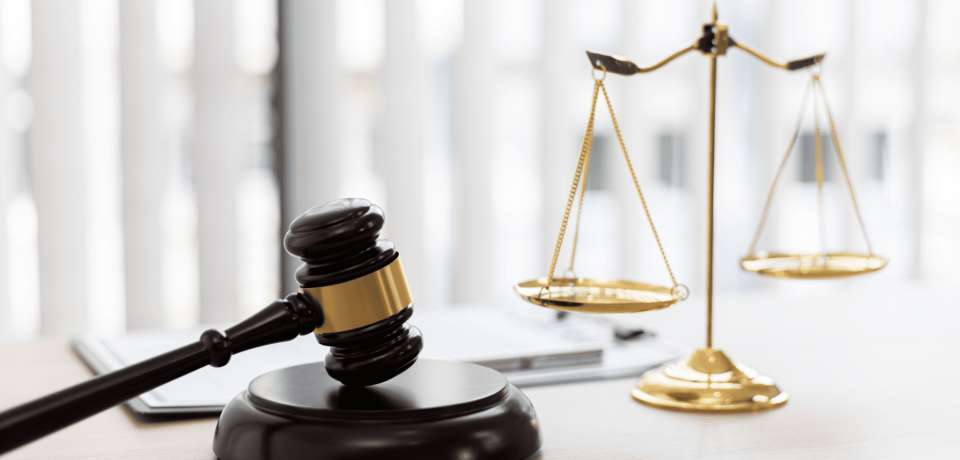 Gavel and scales of justice on legal office desk, law firm specializing in property and civil law in Queensland.