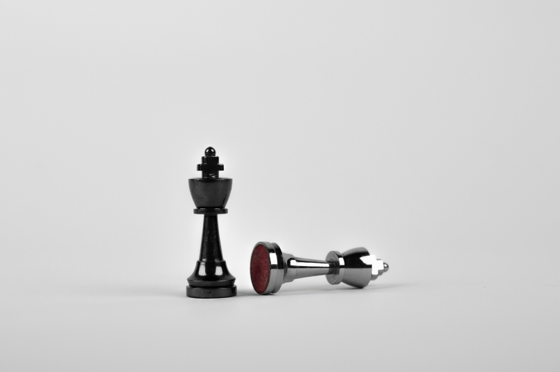 Black chess king and fallen king piece on grey background, representing strategic legal advice in property and civil disputes.