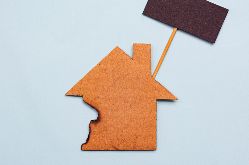 Homeownership symbol with property and Queensland flag on a light blue background.