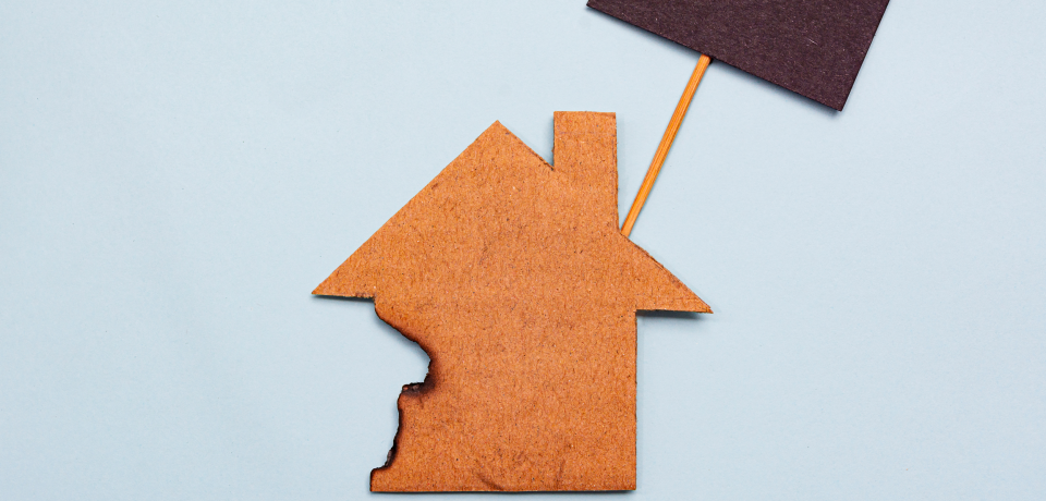 Homeownership symbol with property and Queensland flag on a light blue background.