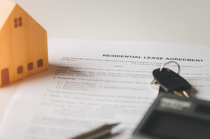 Real estate property model with lease agreement and keys, Queensland law firm focus.