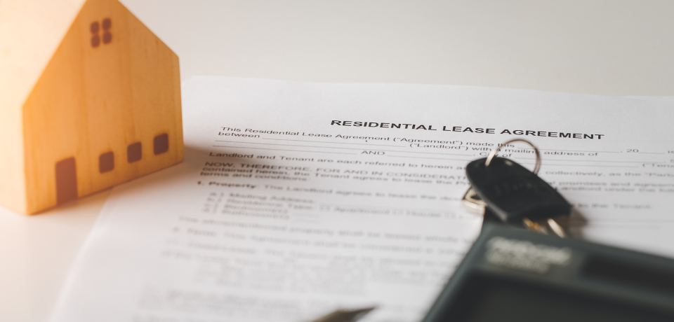 Real estate property model with lease agreement and keys, Queensland law firm focus.